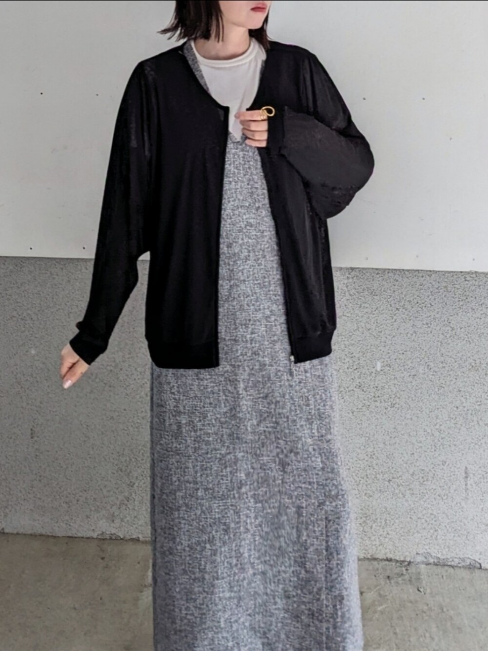 ブラック系のブルゾン、グレー系のワンピース、ホワイト系のショルダーバッグを着用したレディースの春コーディネートの3枚目の写真