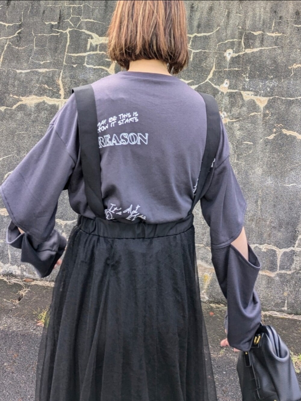 グレー系のTシャツ/カットソー、ブラック系のブーツ、ブラック系のスカートを着用したレディースの秋コーディネートの4枚目の写真