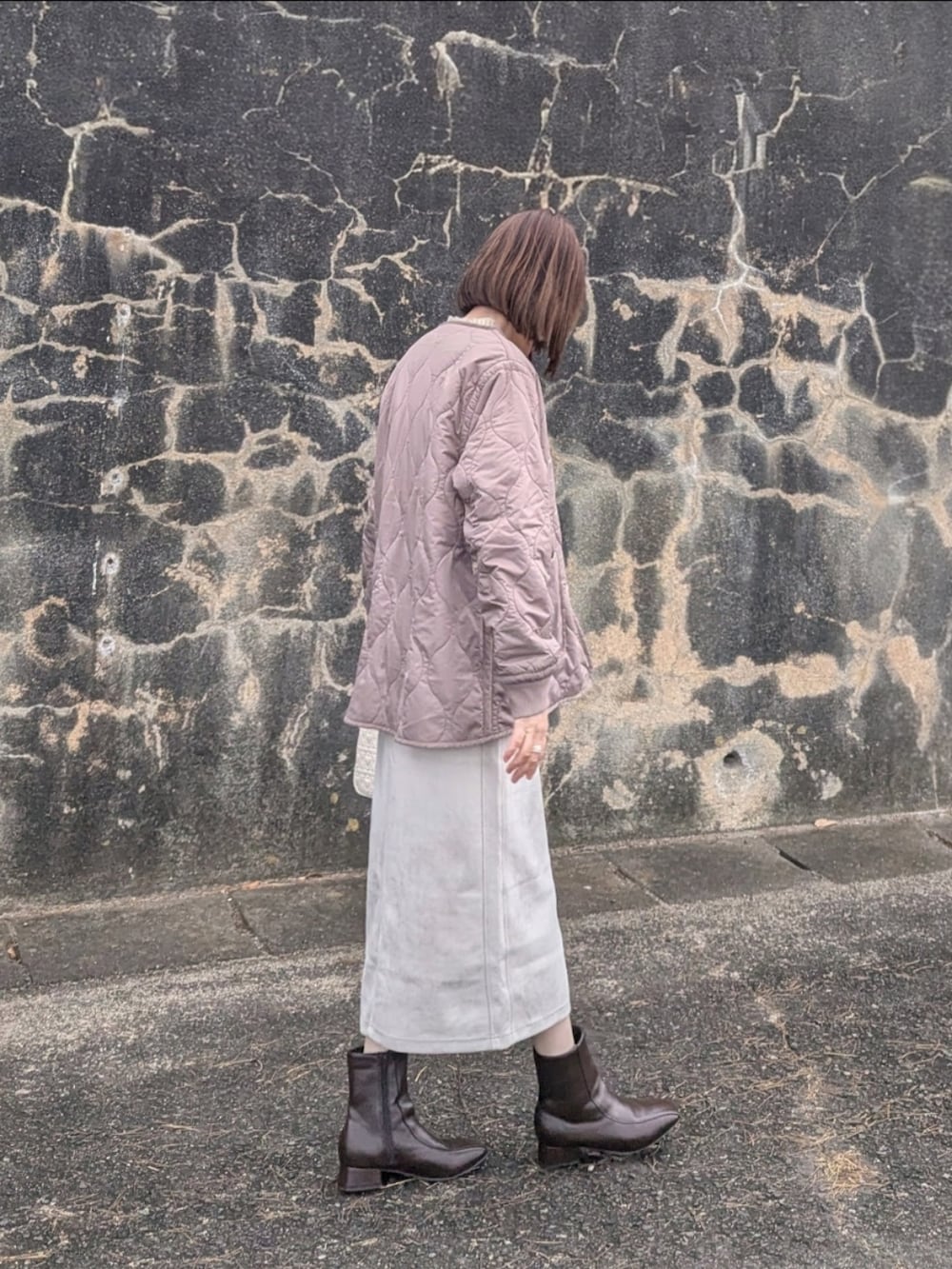 ベージュ系のニット/セーター、ベージュ系のスカート、レッド系のブルゾンを着用したレディースの冬コーディネートの2枚目の写真