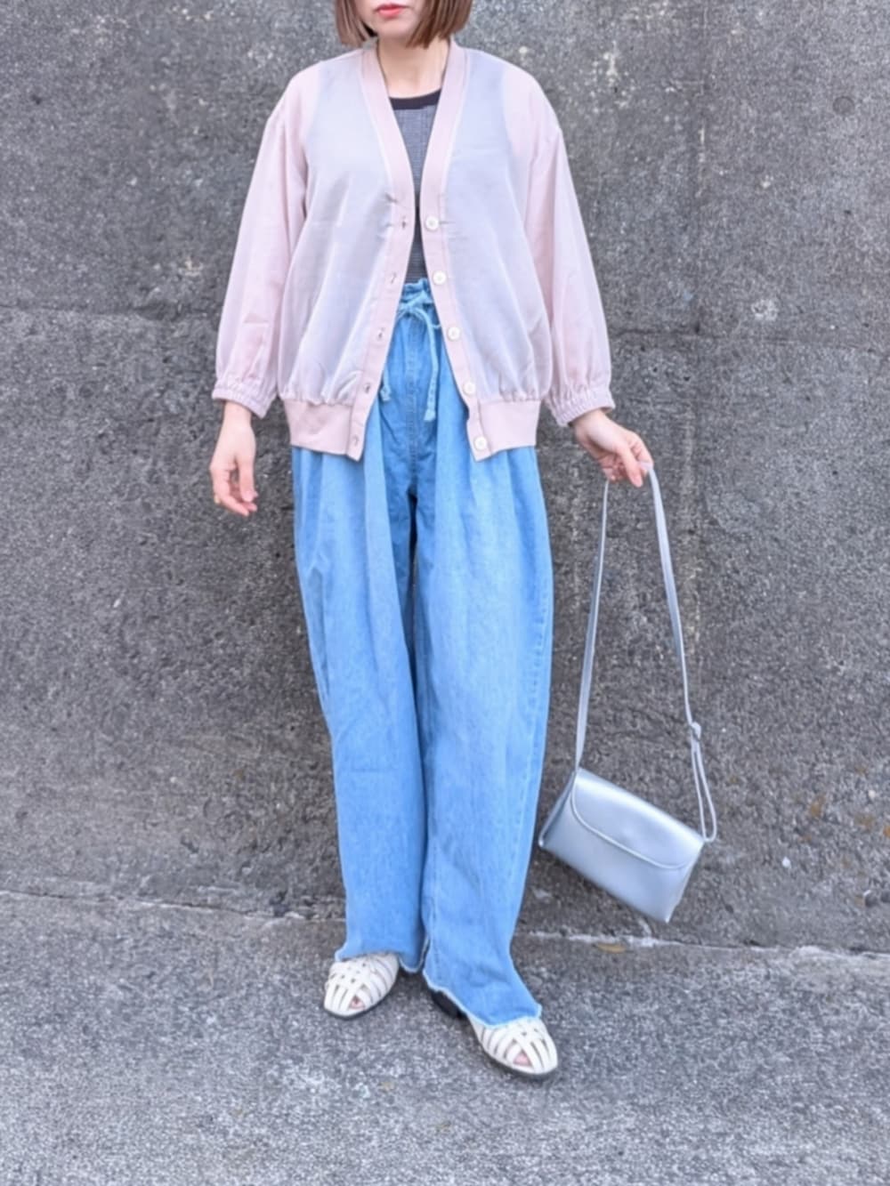 ベージュ系のブルゾン、ブルー系のデニムパンツ、ブラック系のタンクトップを着用したレディースの春コーディネートの2枚目の写真