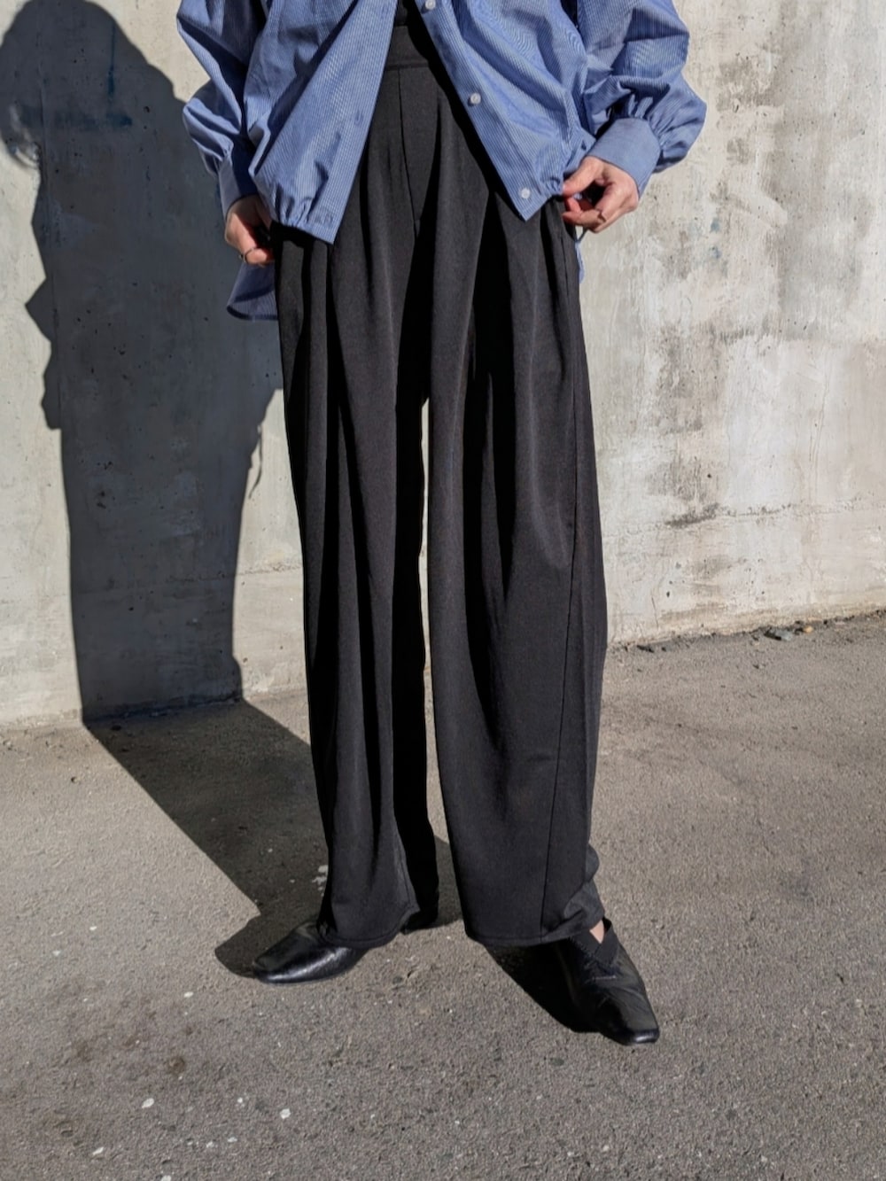 ブラック系のスラックス、ブルー系のシャツ/ブラウスを着用したレディースの春コーディネートの3枚目の写真