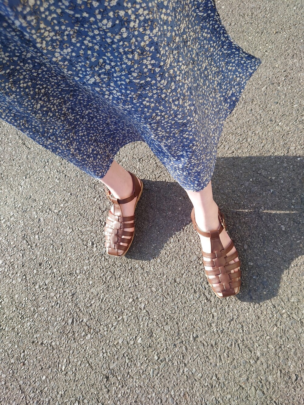 ブルー系のワンピース、ブラウン系のハンドバッグ、ブラウン系のサンダルを着用したレディースの春コーディネートの3枚目の写真