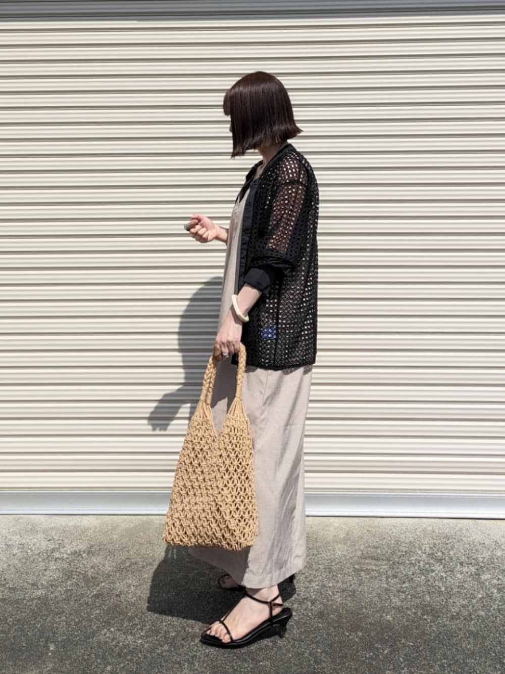 ブラック系のシャツ/ブラウス、ブラック系のタンクトップ、ブラウン系のかごバッグを着用したレディースの夏コーディネートの2枚目の写真