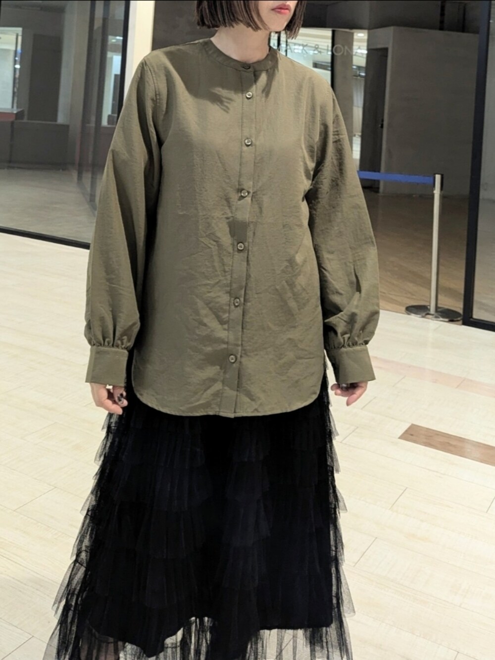 グリーン系のシャツ/ブラウス、ホワイト系のTシャツ/カットソー、ブラック系のブーツを着用したレディースの秋コーディネートの2枚目の写真