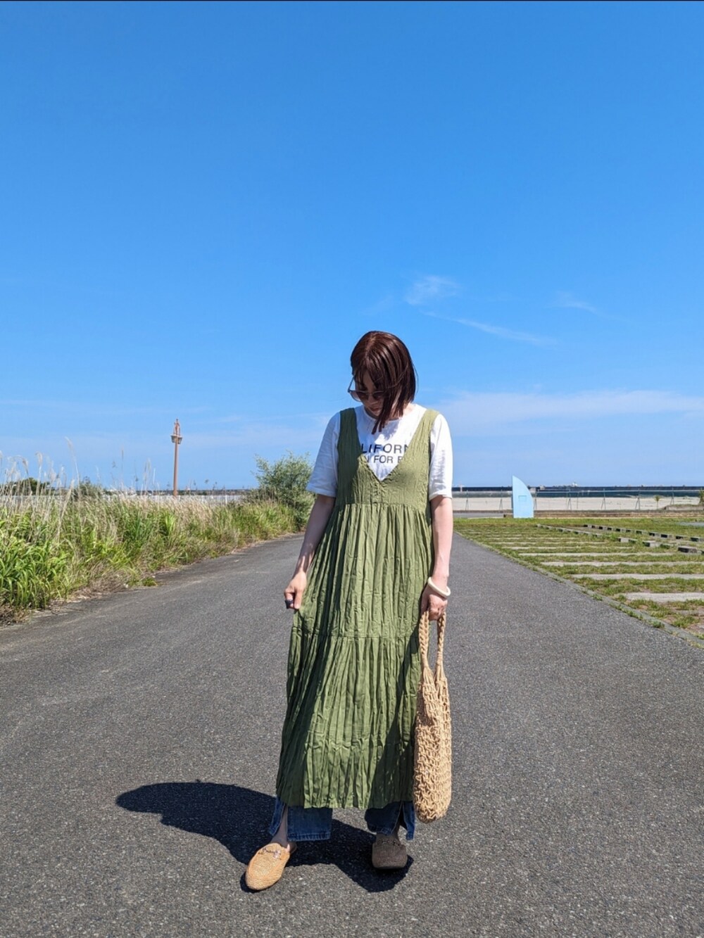 ホワイト系のTシャツ/カットソー、グリーン系のワンピース、ブルー系のデニムパンツを着用したレディースの夏コーディネートの2枚目の写真