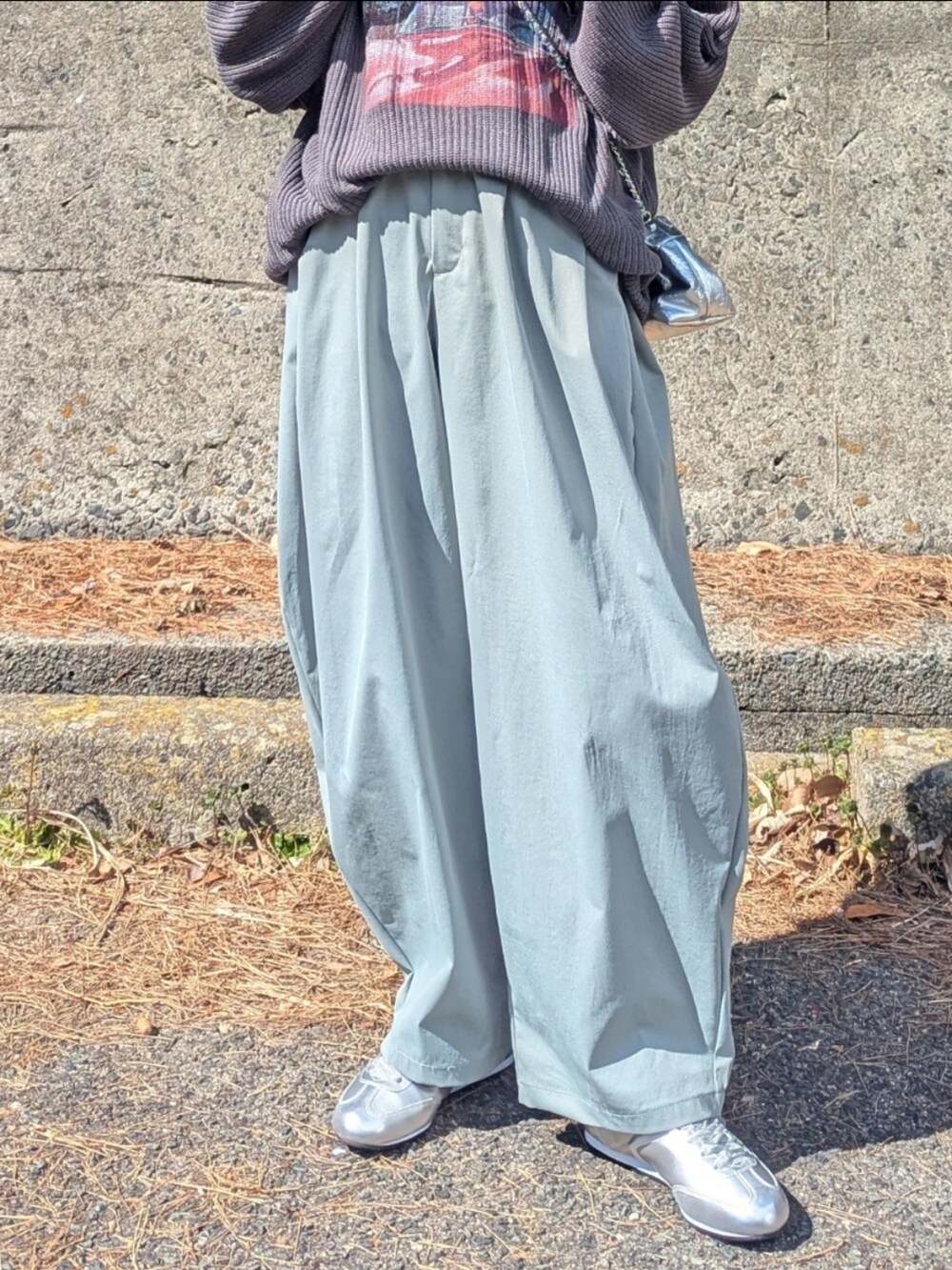 グレー系のニット/セーター、グリーン系のその他パンツ、シルバー系のショルダーバッグを着用したレディースの春コーディネートの3枚目の写真