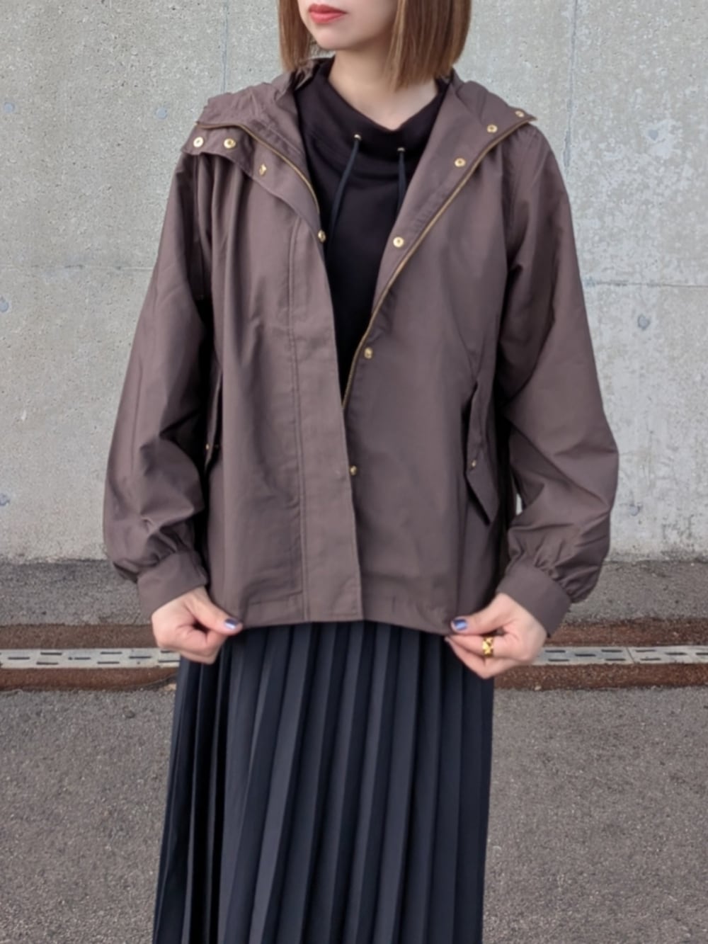 ブラウン系のブルゾン、ブラック系のスウェット、グレー系のスカートを着用したレディースの秋コーディネートの2枚目の写真