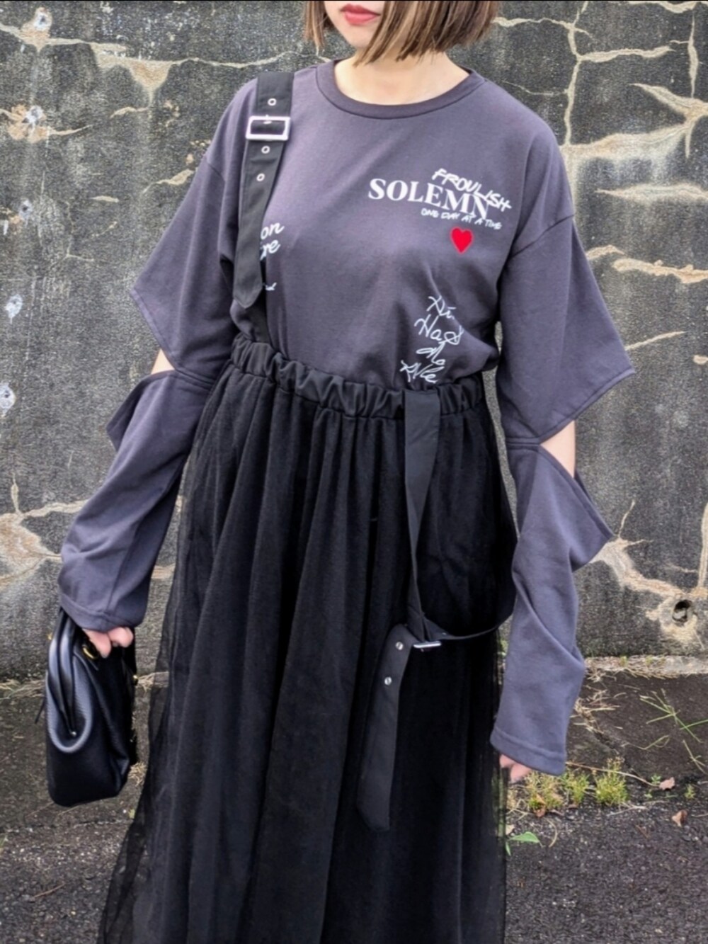 グレー系のTシャツ/カットソー、ブラック系のブーツ、ブラック系のスカートを着用したレディースの秋コーディネートの3枚目の写真