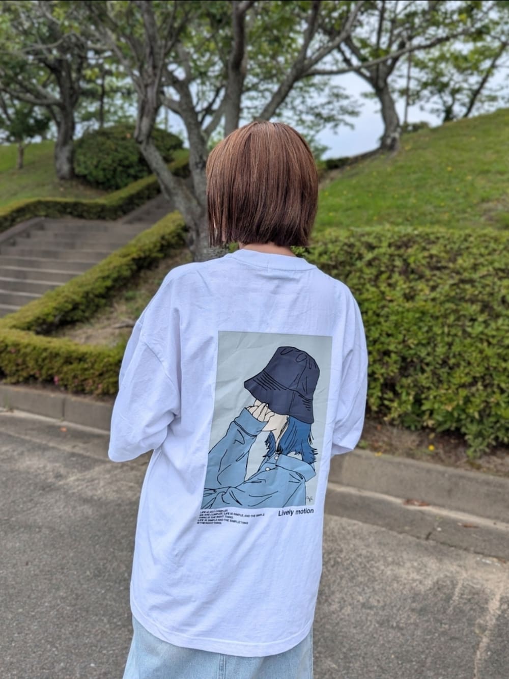 ホワイト系のTシャツ/カットソー、ブルー系のスカート、ブラウン系のサンダルを着用したレディースの夏コーディネートの2枚目の写真