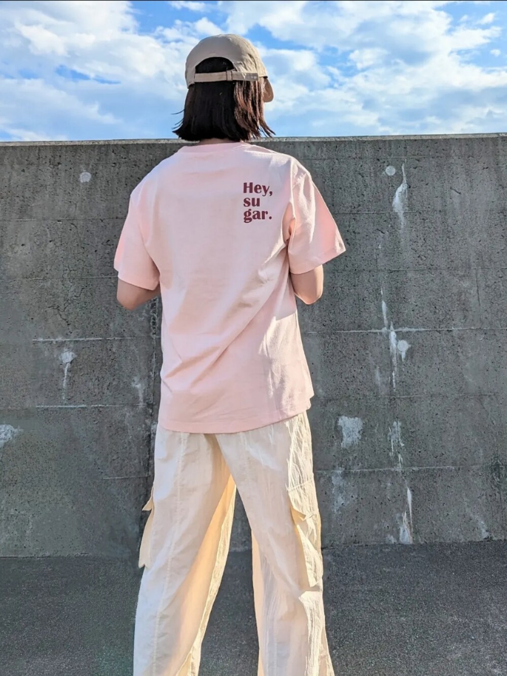 ホワイト系のカーゴパンツ、ベージュ系のショルダーバッグ、ブラウン系のサンダルを着用したレディースの夏コーディネートの2枚目の写真