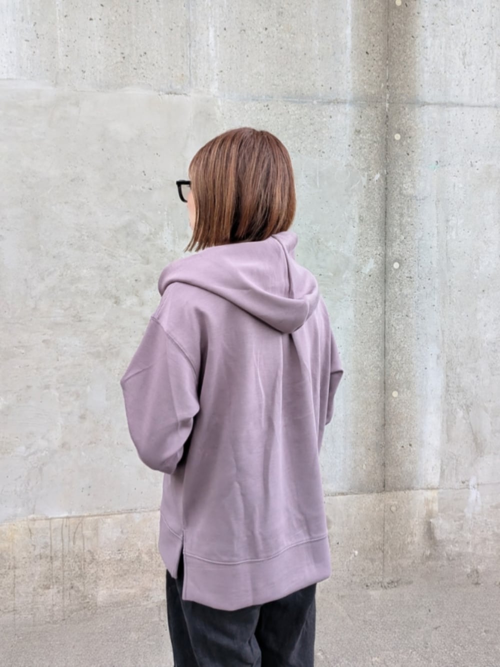 ブラウン系のパーカー、ブラック系のスニーカー、ホワイト系のバックパック/リュックを着用したレディースの秋コーディネートの4枚目の写真