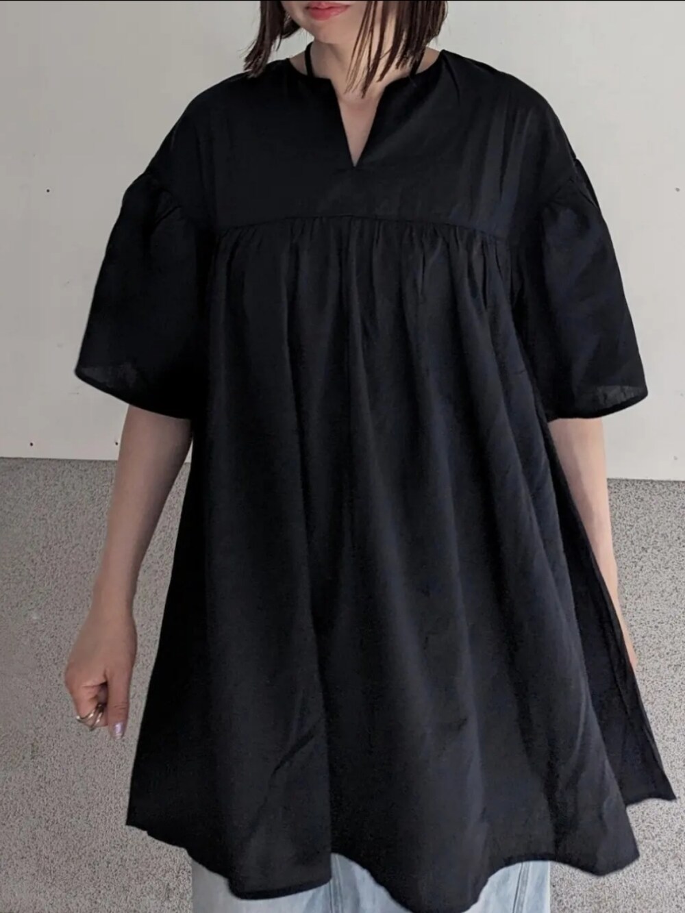 ブラック系のシャツ/ブラウス、ブルー系のスカート、ホワイト系のハンドバッグを着用したレディースの夏コーディネートの2枚目の写真