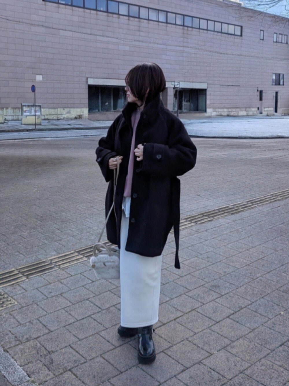 ピンク系のスウェット、ベージュ系のショルダーバッグ、ブラック系のブーツを着用したレディースの冬コーディネートの5枚目の写真