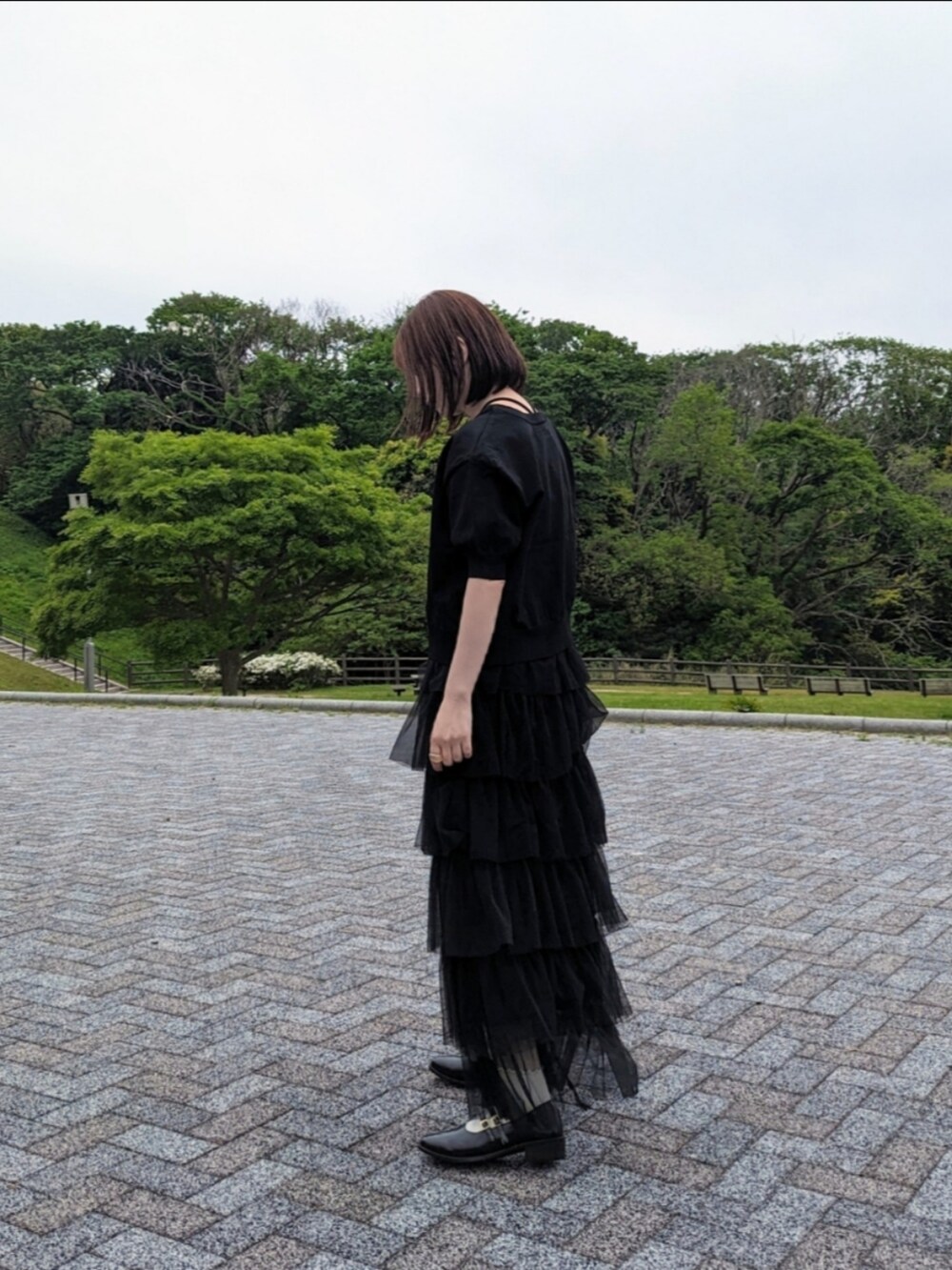 ブラック系のカーディガン/ボレロ、ブラック系のキャミソール、ブラック系のスカートを着用したレディースの春コーディネートの4枚目の写真