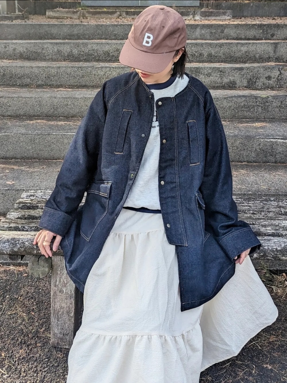 ブルー系のデニムジャケット、ベージュ系のスウェット、ブラック系のショルダーバッグを着用したレディースの冬コーディネートの3枚目の写真