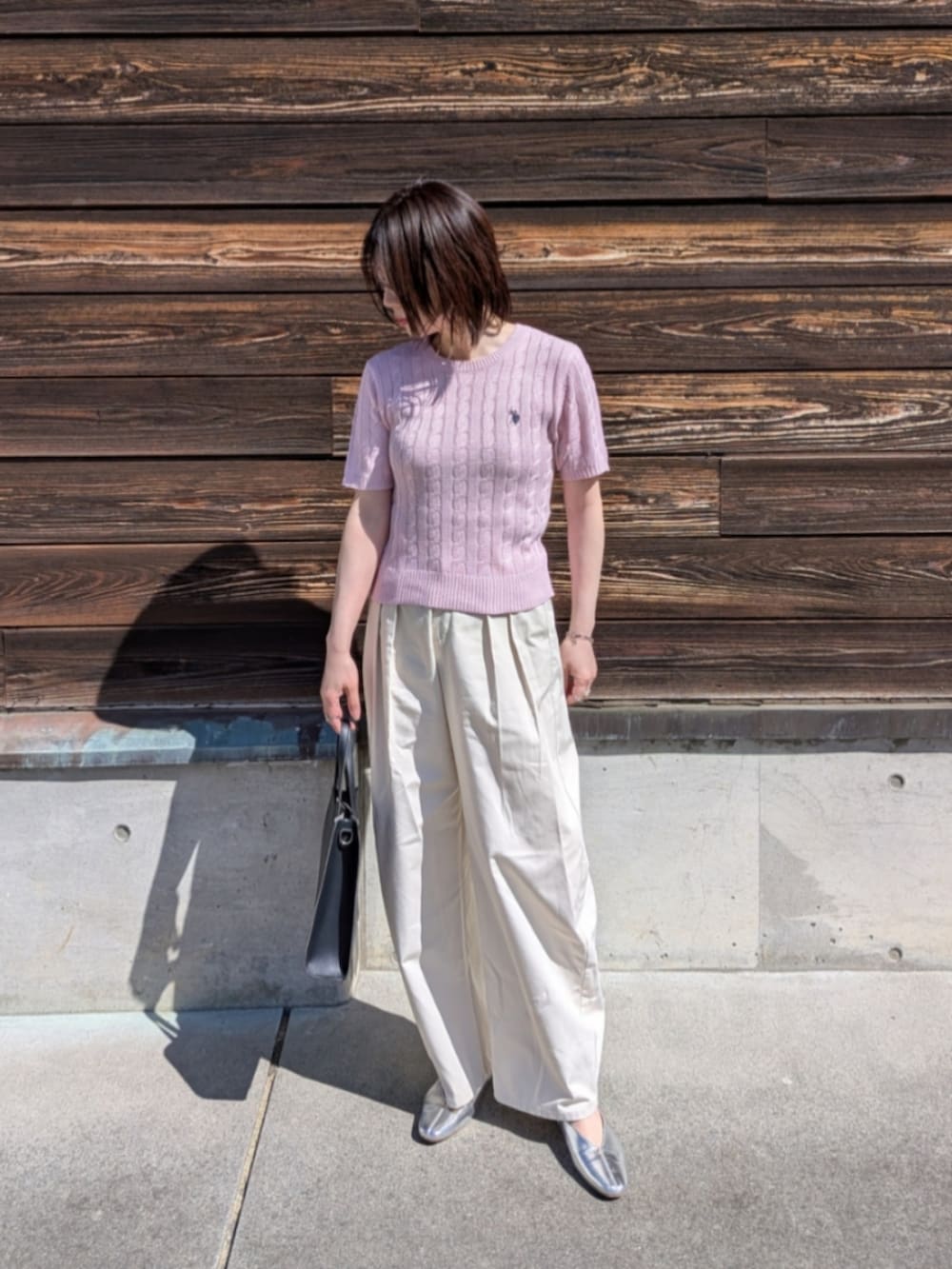 ピンク系のニット/セーター、ブルー系のデニムジャケット、ブラック系のショルダーバッグを着用したレディースの春コーディネートの2枚目の写真