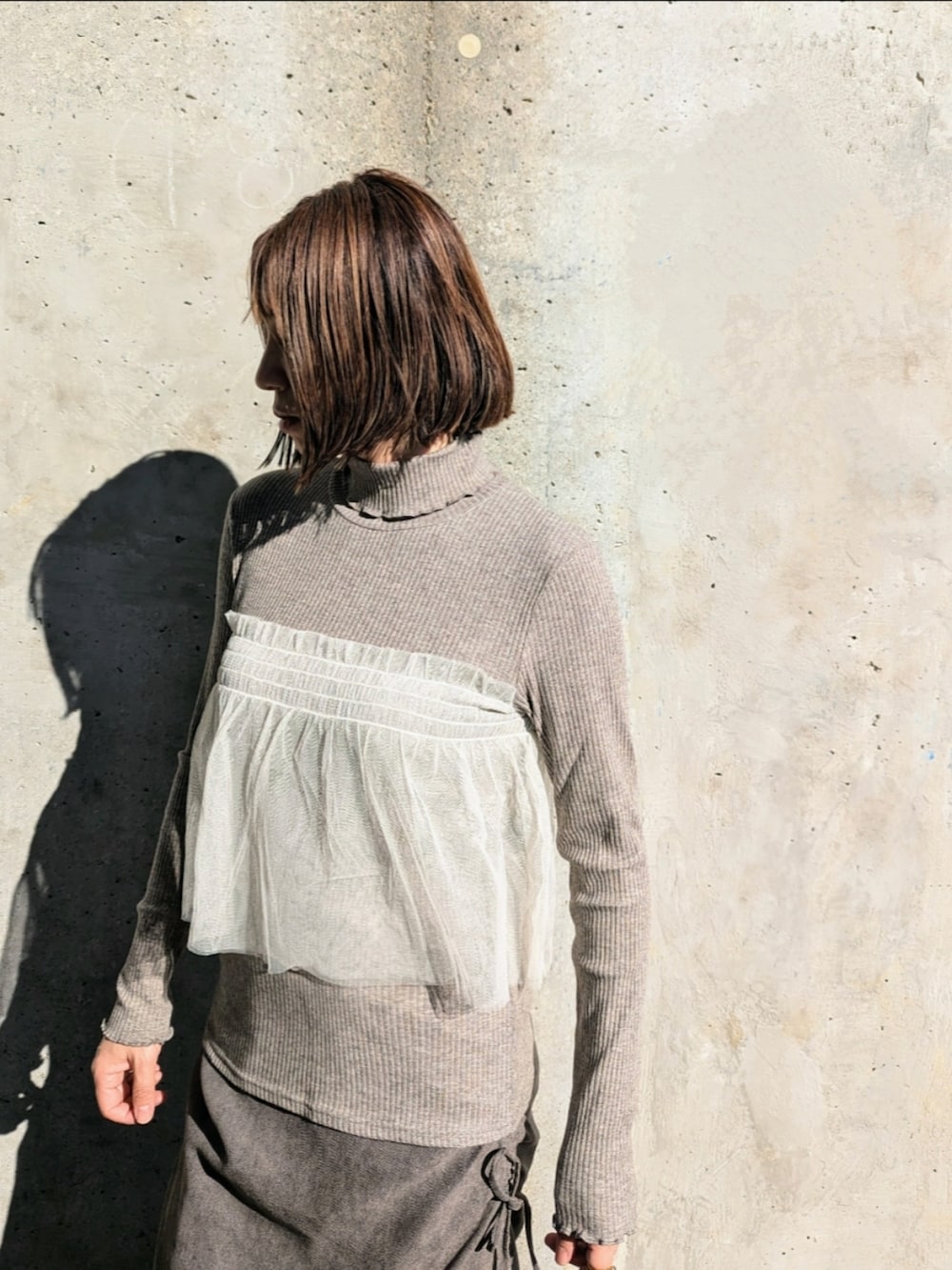 グレー系のTシャツ/カットソー、グレー系のスカートを着用したレディースの秋コーディネートの4枚目の写真