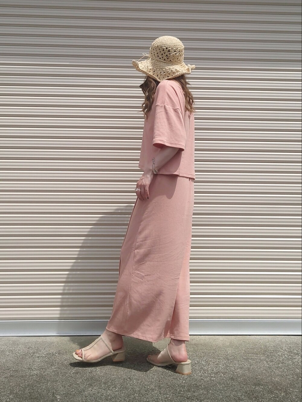 ピンク系のTシャツ/カットソー、ピンク系のスカート、ベージュ系のハットを着用したレディースの夏コーディネートの2枚目の写真