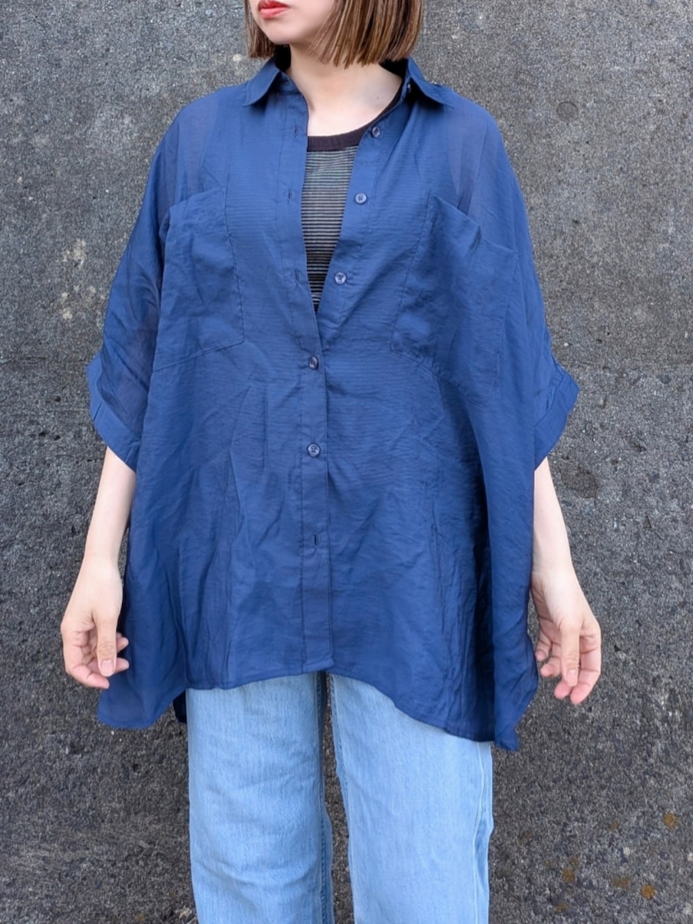 ブルー系のシャツ/ブラウス、ブラック系のタンクトップ、ホワイト系のサンダルを着用したレディースの春コーディネートの4枚目の写真