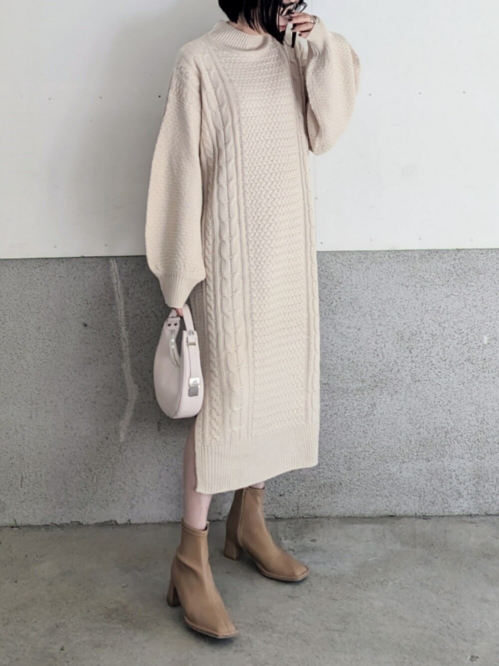 ホワイト系のワンピース、グレー系のベスト、ホワイト系のハンドバッグを着用したレディースの秋コーディネートの4枚目の写真