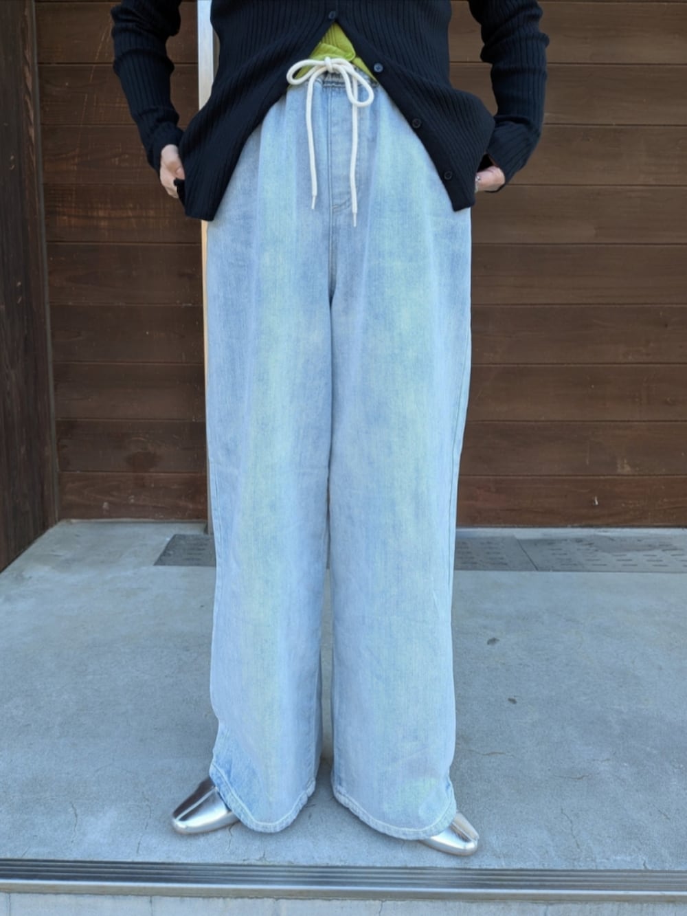 ブルー系のデニムパンツ、ブラック系のショルダーバッグ、ピンク系のカーディガン/ボレロを着用したレディースの春コーディネートの4枚目の写真