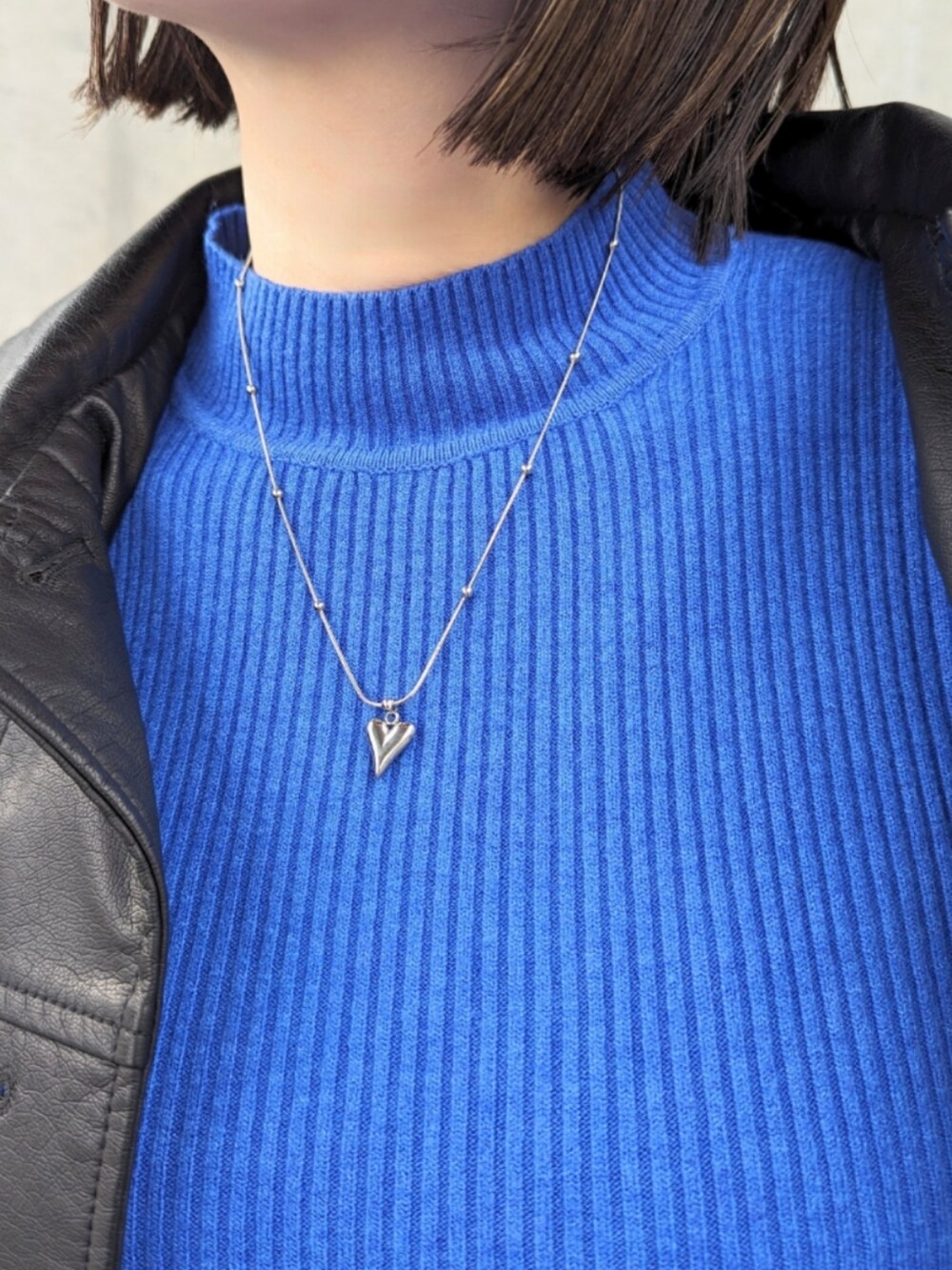 ブラック系のブルゾン、ブラック系のブーツ、ブルー系のニット/セーターを着用したレディースの冬コーディネートの3枚目の写真