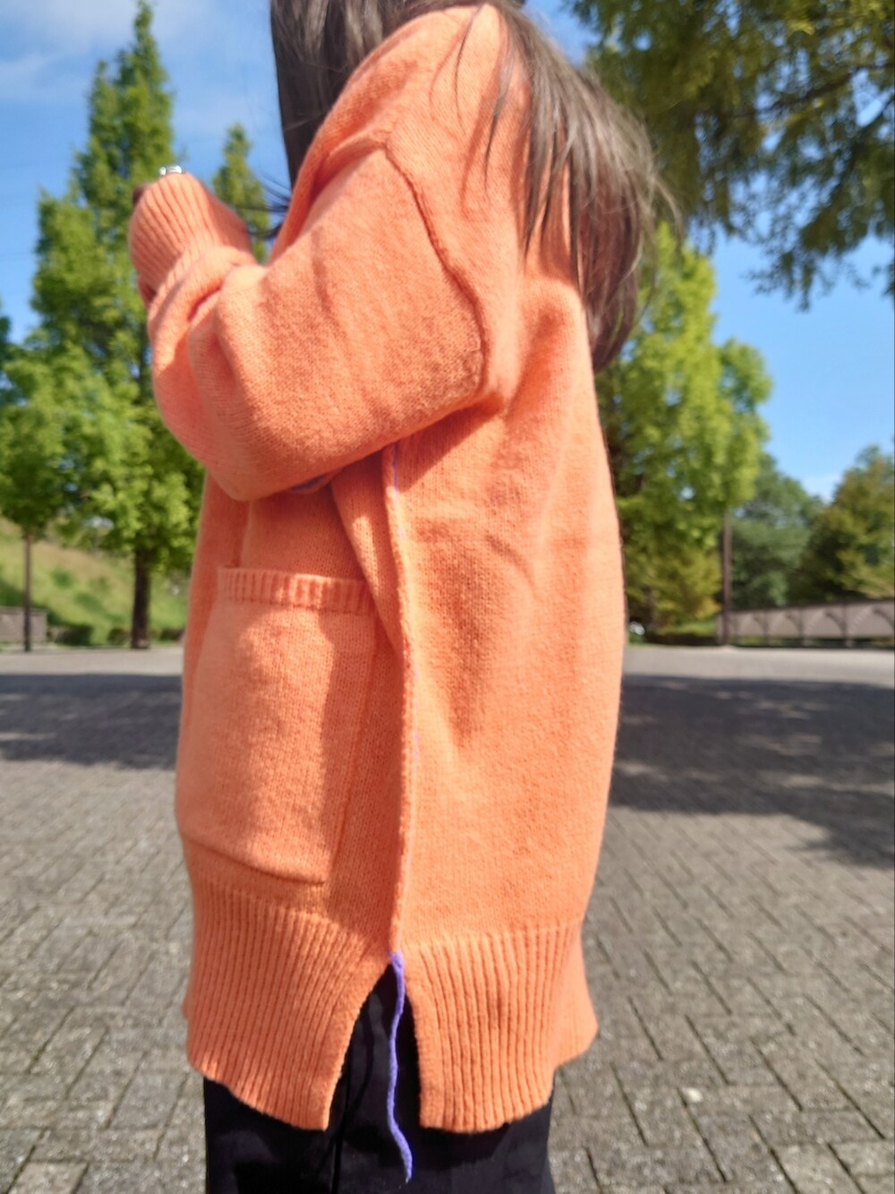 オレンジ系のカーディガン/ボレロ、ブラック系のサロペット/オーバーオール、ブラウン系のパンプスを着用したレディースの秋コーディネートの3枚目の写真