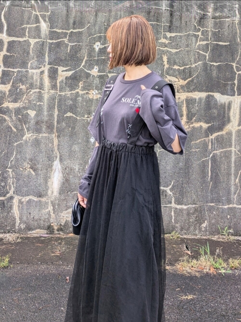 グレー系のTシャツ/カットソー、ブラック系のブーツ、ブラック系のスカートを着用したレディースの秋コーディネートの2枚目の写真