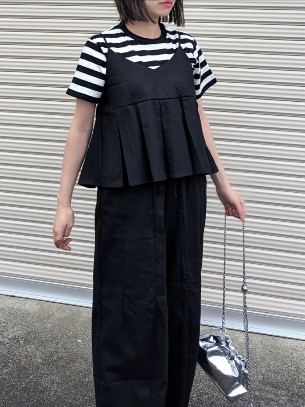 ブラック系のセットアップ、ブラック系のTシャツ/カットソー、シルバー系のショルダーバッグを着用したレディースの春コーディネートの3枚目の写真