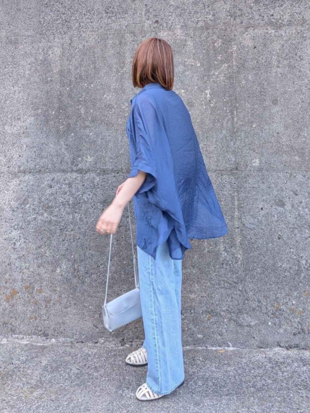 ブルー系のシャツ/ブラウス、ブラック系のタンクトップ、ホワイト系のサンダルを着用したレディースの春コーディネートの3枚目の写真