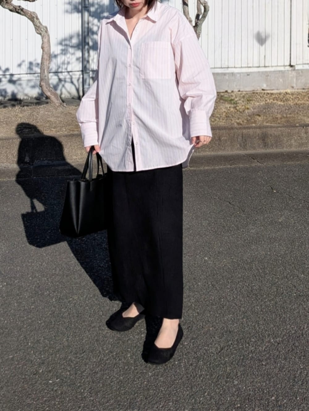 ピンク系のシャツ/ブラウス、ブルー系のデニムジャケット、ブラック系のパンプスを着用したレディースの春コーディネートの3枚目の写真