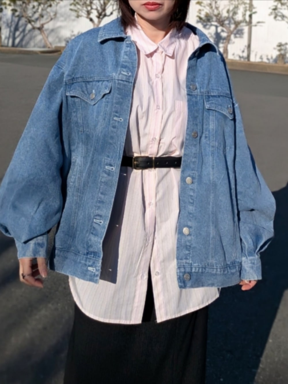 ピンク系のシャツ/ブラウス、ブルー系のデニムジャケット、ブラック系のパンプスを着用したレディースの春コーディネートの2枚目の写真