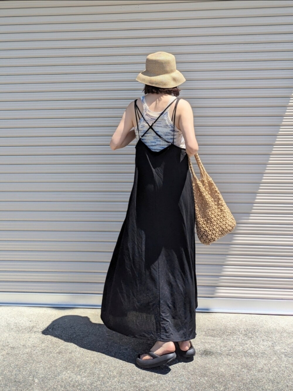 ホワイト系のその他トップス、ブラック系のワンピース、ブラウン系のかごバッグを着用したレディースの夏コーディネートの2枚目の写真