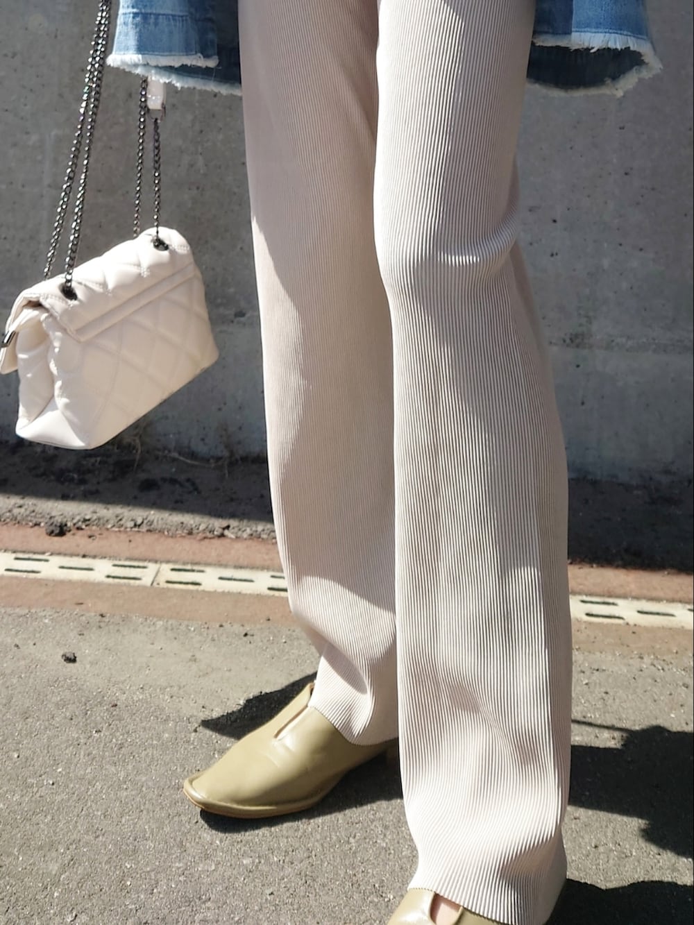 ホワイト系のその他パンツ、ホワイト系のスウェット、ホワイト系のショルダーバッグを着用したレディースの春コーディネートの2枚目の写真