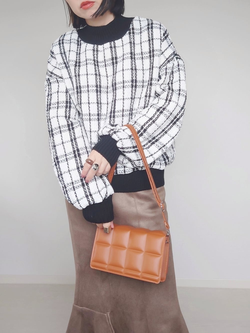 ホワイト系のその他トップス、ブラウン系のクラッチバッグ、ホワイト系のブーツを着用したレディースの秋コーディネートの3枚目の写真