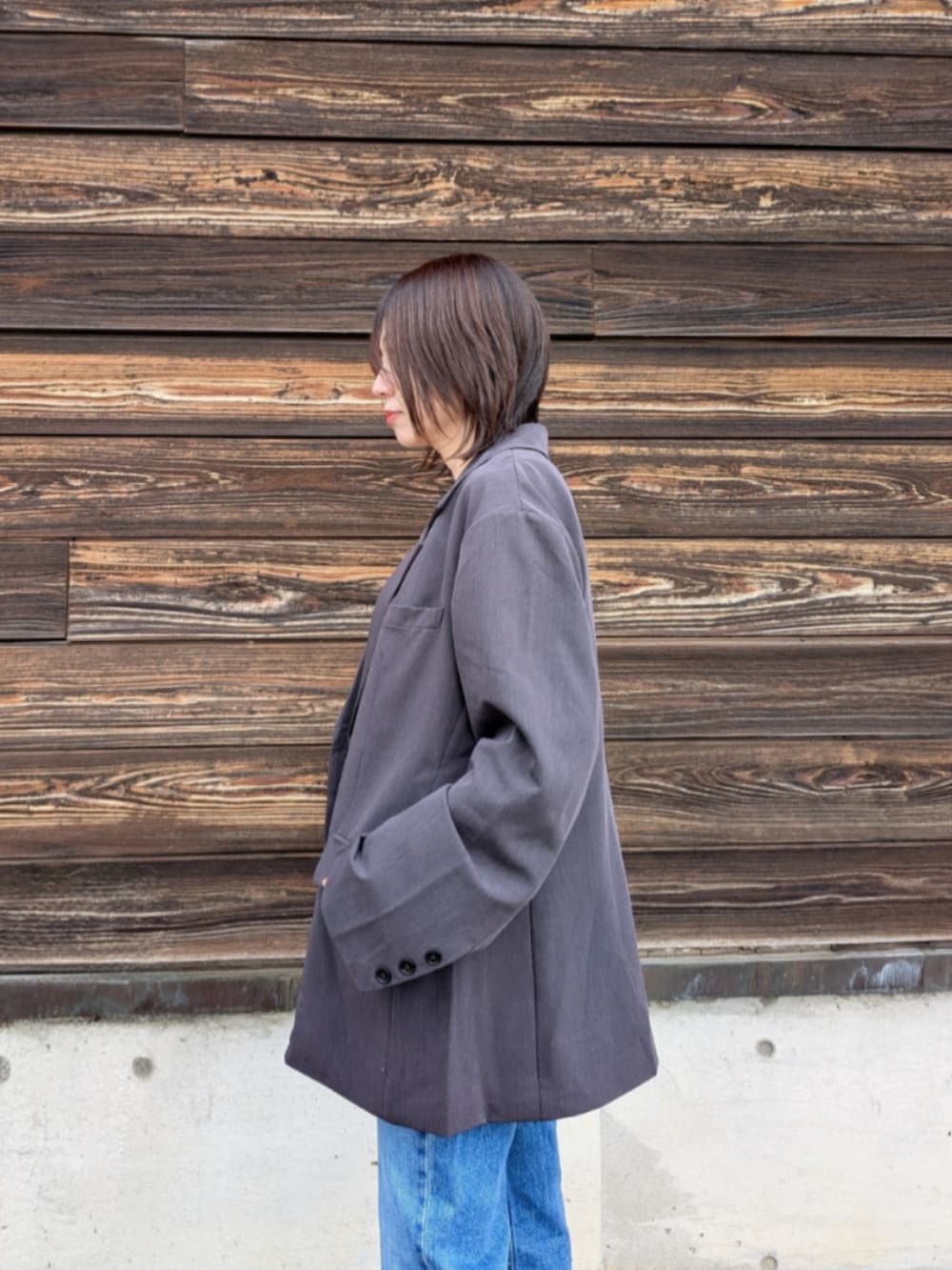 グレー系のテーラードジャケット、ブラック系のキャミソール、ホワイト系のショルダーバッグを着用したレディースの春コーディネートの4枚目の写真