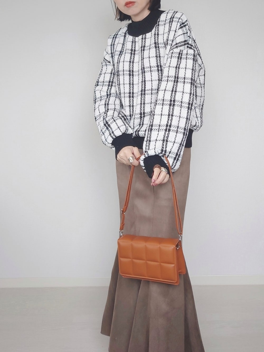 ホワイト系のその他トップス、ブラウン系のクラッチバッグ、ホワイト系のブーツを着用したレディースの秋コーディネートの2枚目の写真