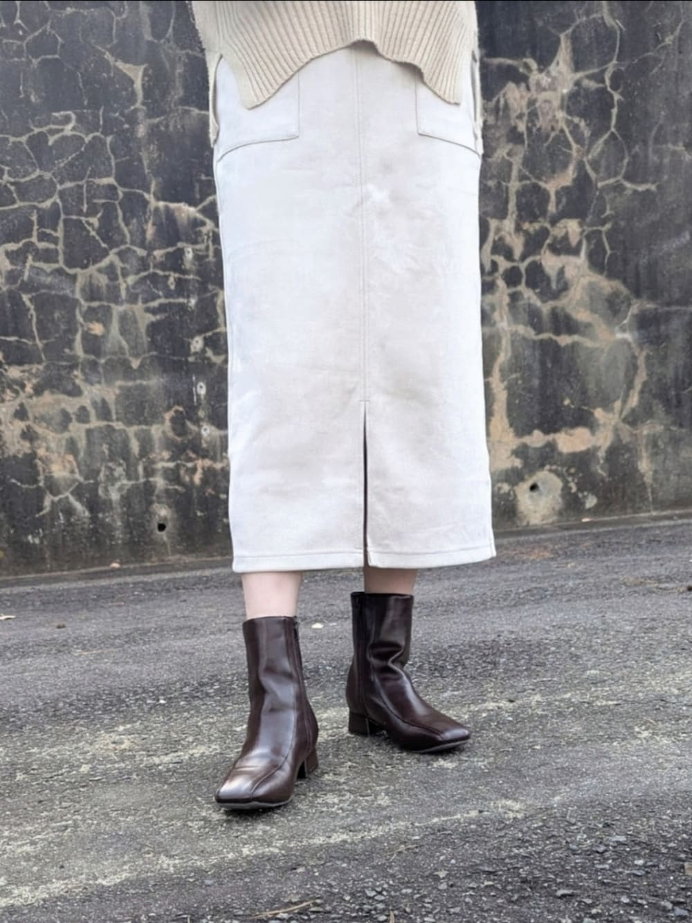 ベージュ系のニット/セーター、ベージュ系のスカート、レッド系のブルゾンを着用したレディースの冬コーディネートの5枚目の写真