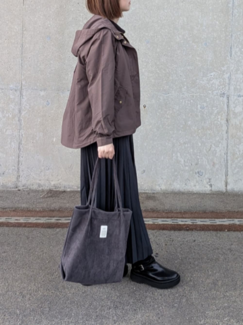 ブラウン系のブルゾン、ブラック系のスウェット、グレー系のスカートを着用したレディースの秋コーディネートの5枚目の写真