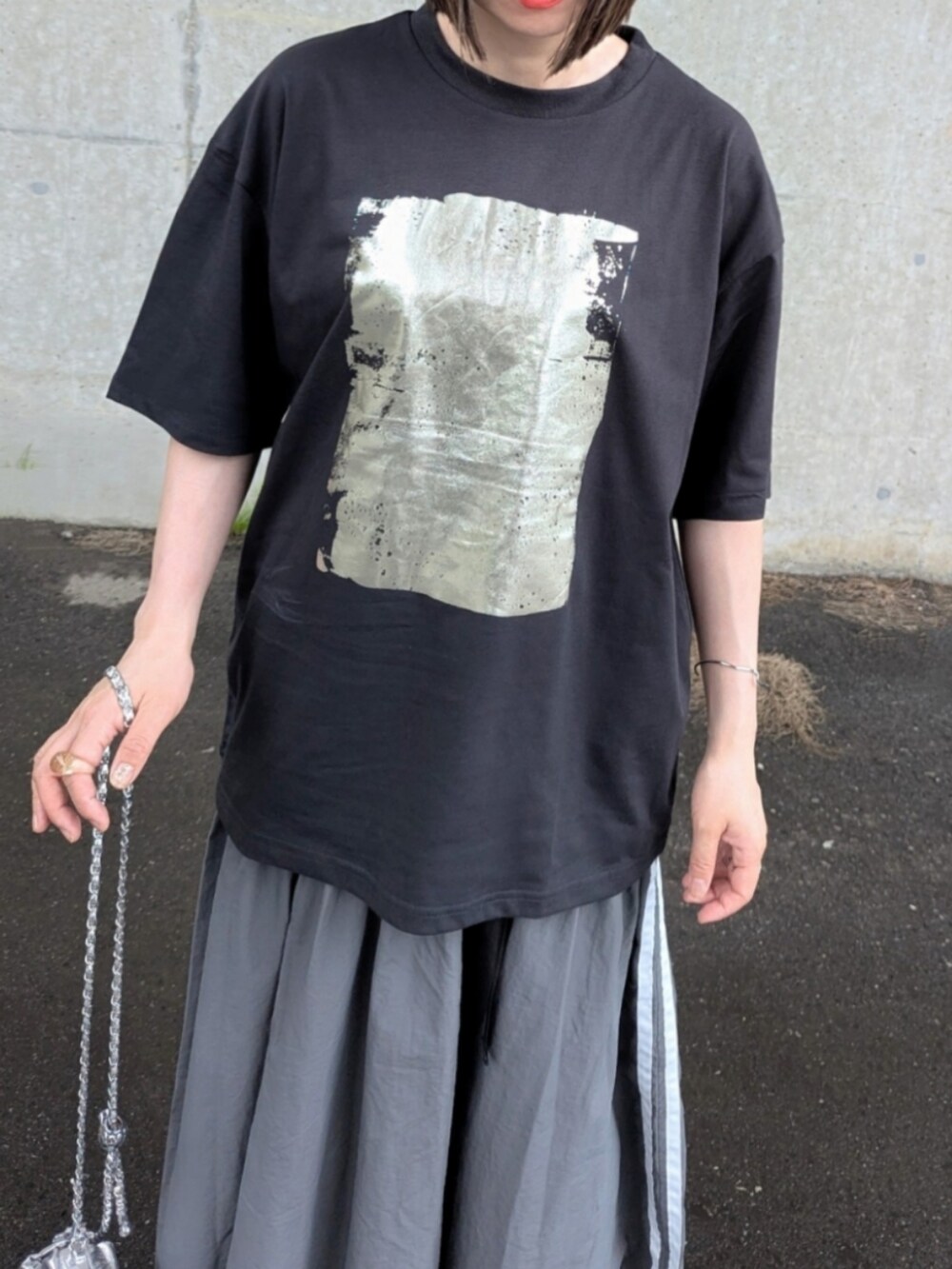 ブラック系のTシャツ/カットソー、グレー系のスカート、シルバー系のショルダーバッグを着用したレディースの夏コーディネートの3枚目の写真