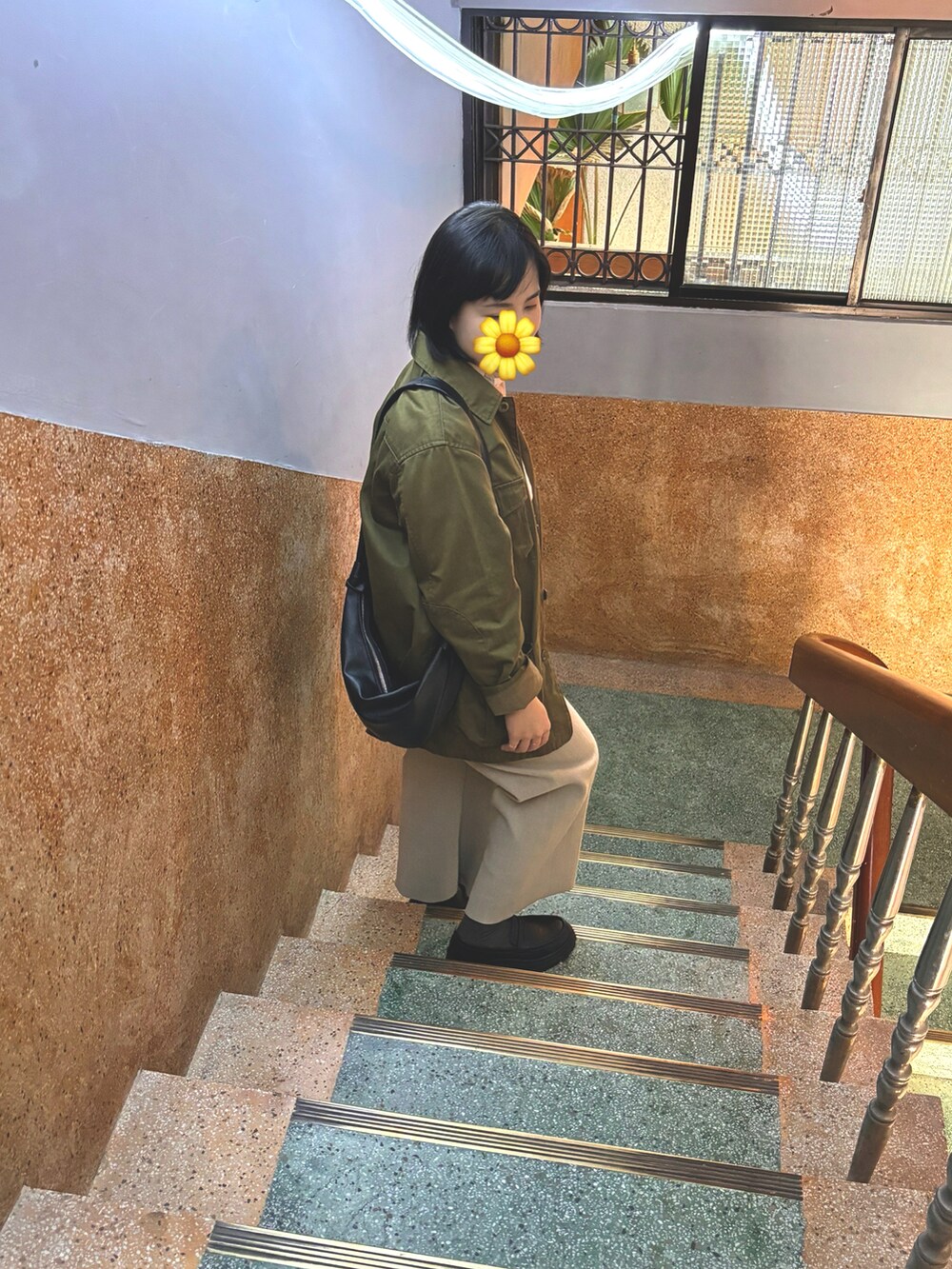 グリーン系のピーコート、ベージュ系のシャツ/ブラウス、ブラック系のショルダーバッグを着用したレディースの春コーディネートの3枚目の写真