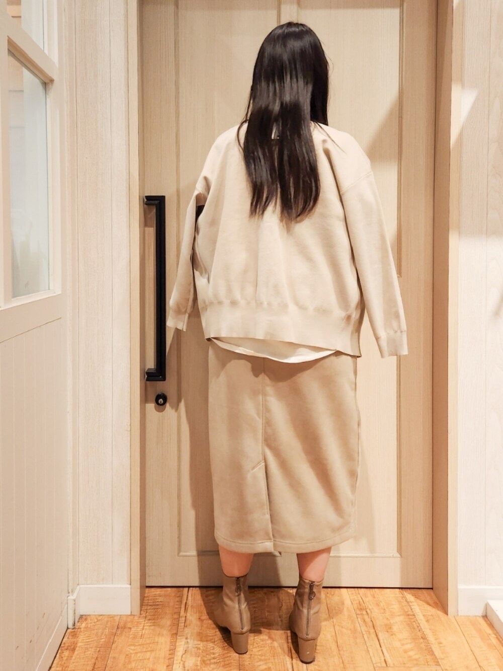 ホワイト系のカーディガン/ボレロ、ホワイト系のTシャツ/カットソー、ベージュ系のスカートを着用したレディースの冬コーディネートの3枚目の写真