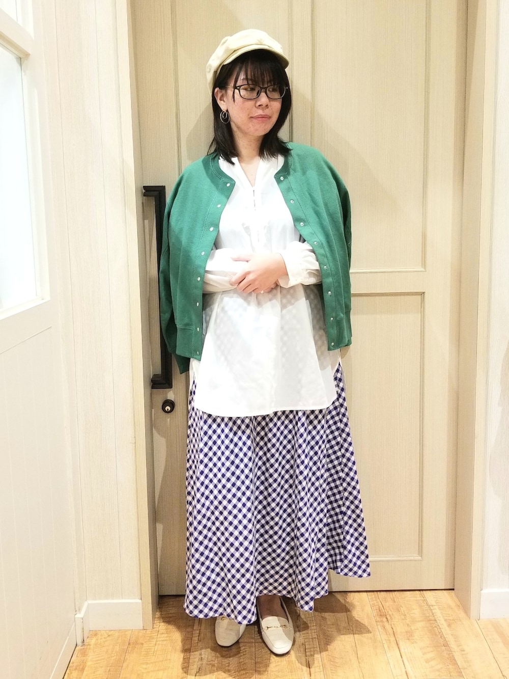 グリーン系のカーディガン/ボレロ、ホワイト系のシャツ/ブラウス、ベージュ系のトートバッグを着用したレディースの春コーディネートの2枚目の写真