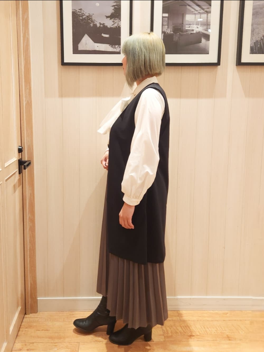 ホワイト系のシャツ/ブラウス、ブラック系のベスト、ブラウン系のスカートを着用したレディースの冬コーディネートの2枚目の写真