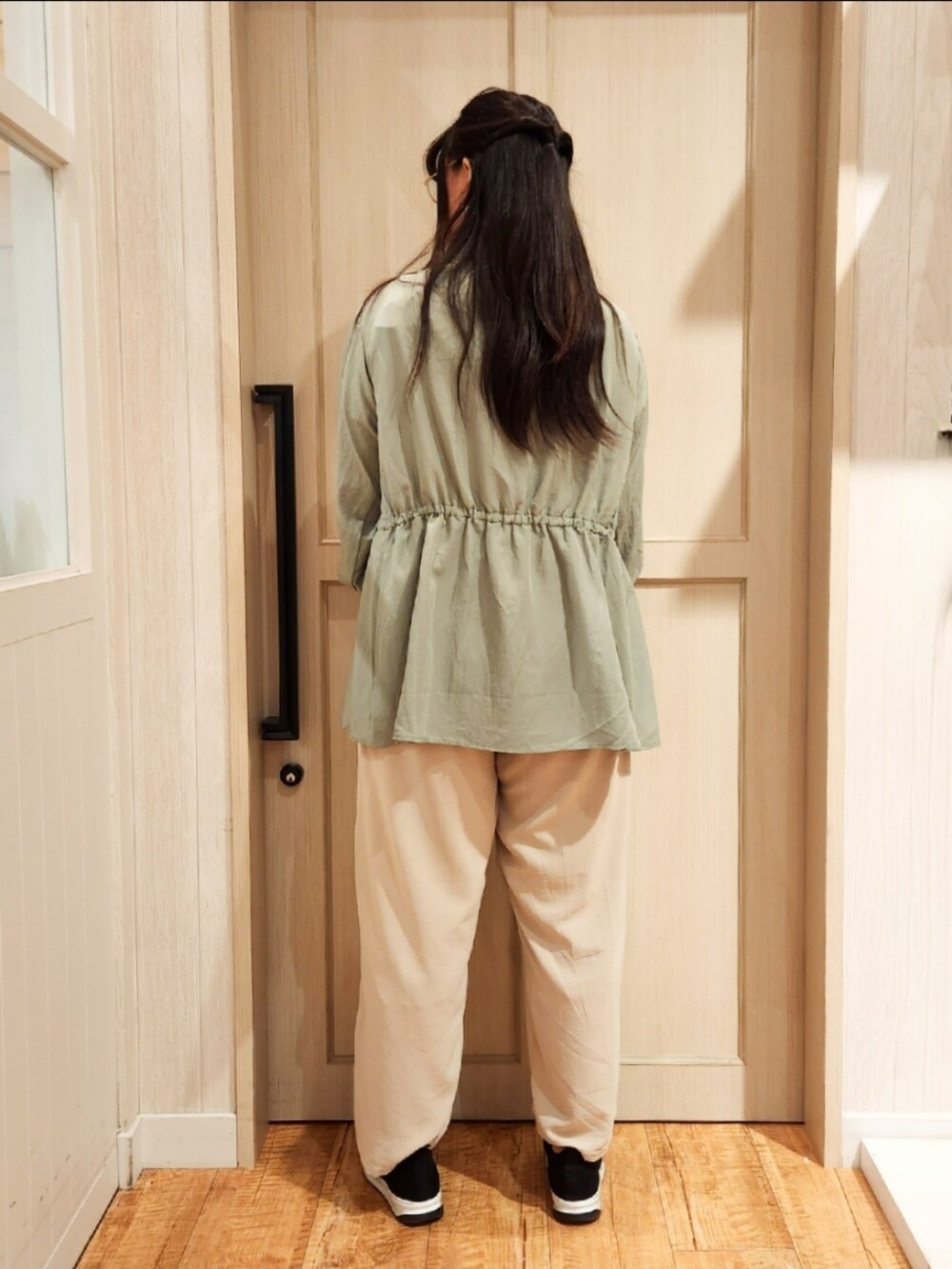 グリーン系のシャツ/ブラウス、ホワイト系のTシャツ/カットソー、ブラック系のスニーカーを着用したレディースの秋コーディネートの3枚目の写真
