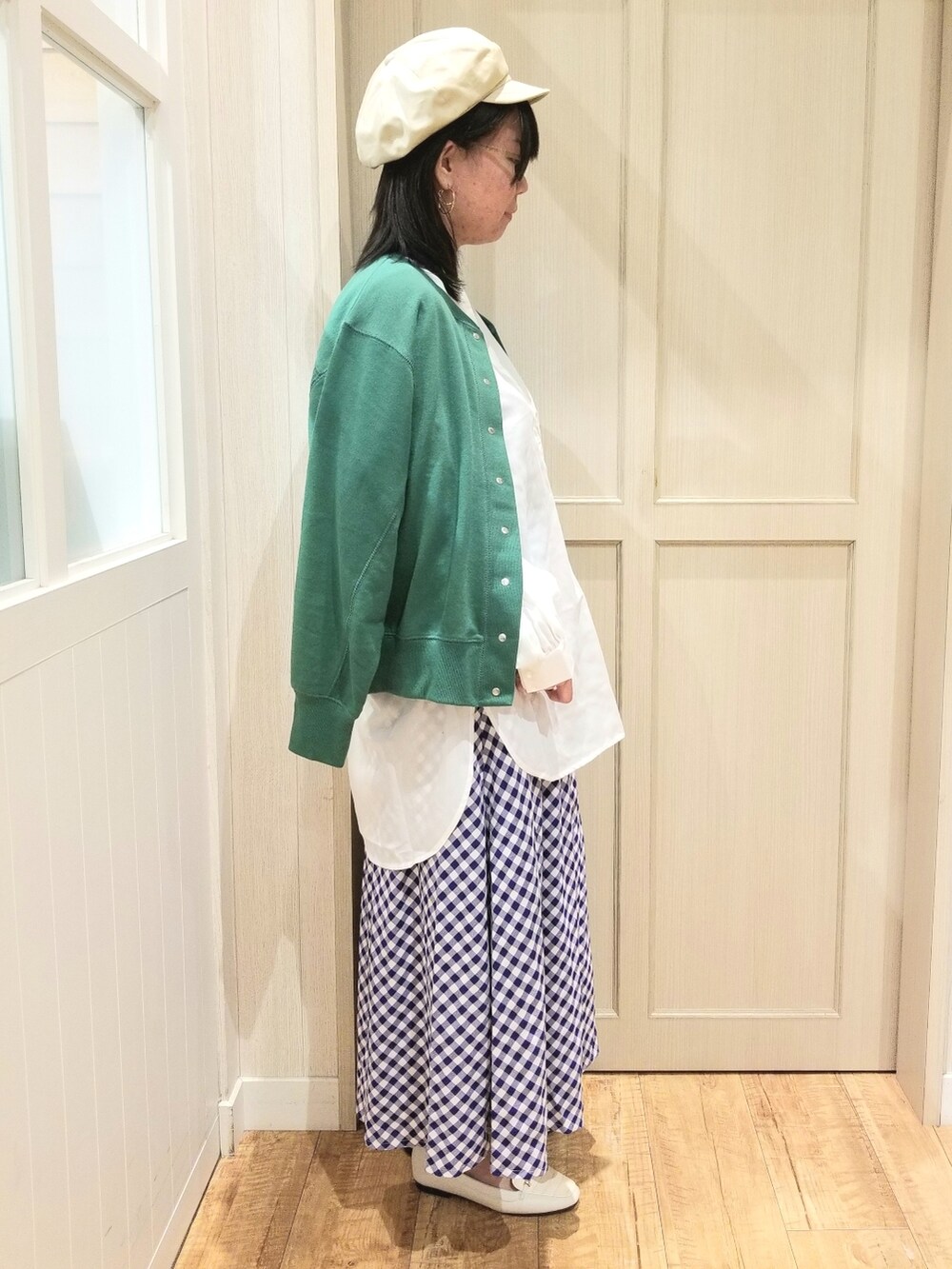 グリーン系のカーディガン/ボレロ、ホワイト系のシャツ/ブラウス、ベージュ系のトートバッグを着用したレディースの春コーディネートの3枚目の写真