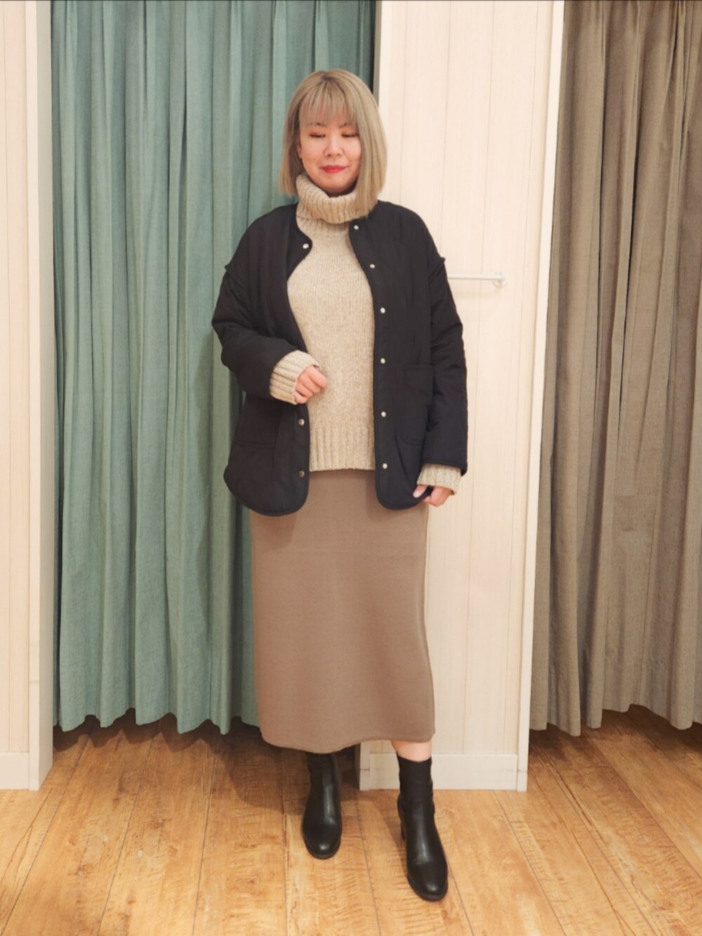 ブラック系のその他アウター、ベージュ系のニット/セーター、ブラウン系のスカートを着用したレディースの冬コーディネートの4枚目の写真
