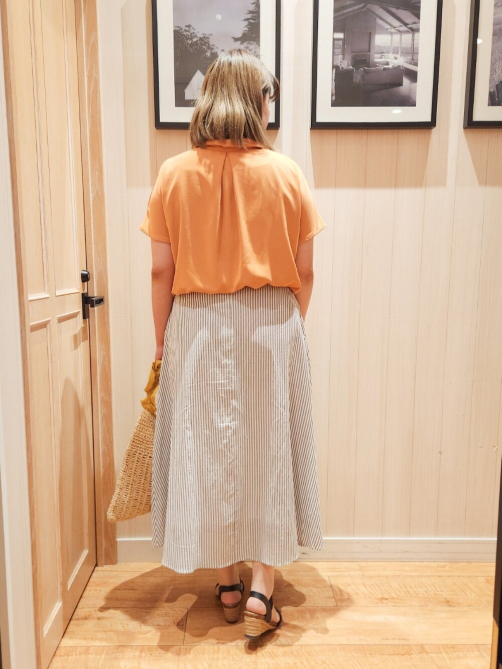 オレンジ系のシャツ/ブラウス、グレー系のスカート、イエロー系のトートバッグを着用したレディースの夏コーディネートの3枚目の写真