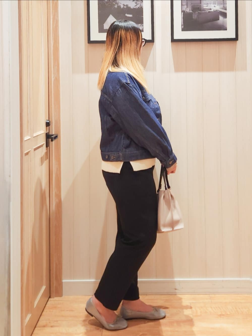 ブルー系のデニムジャケット、ホワイト系のニット/セーター、ブラック系のその他パンツを着用したレディースの春コーディネートの2枚目の写真