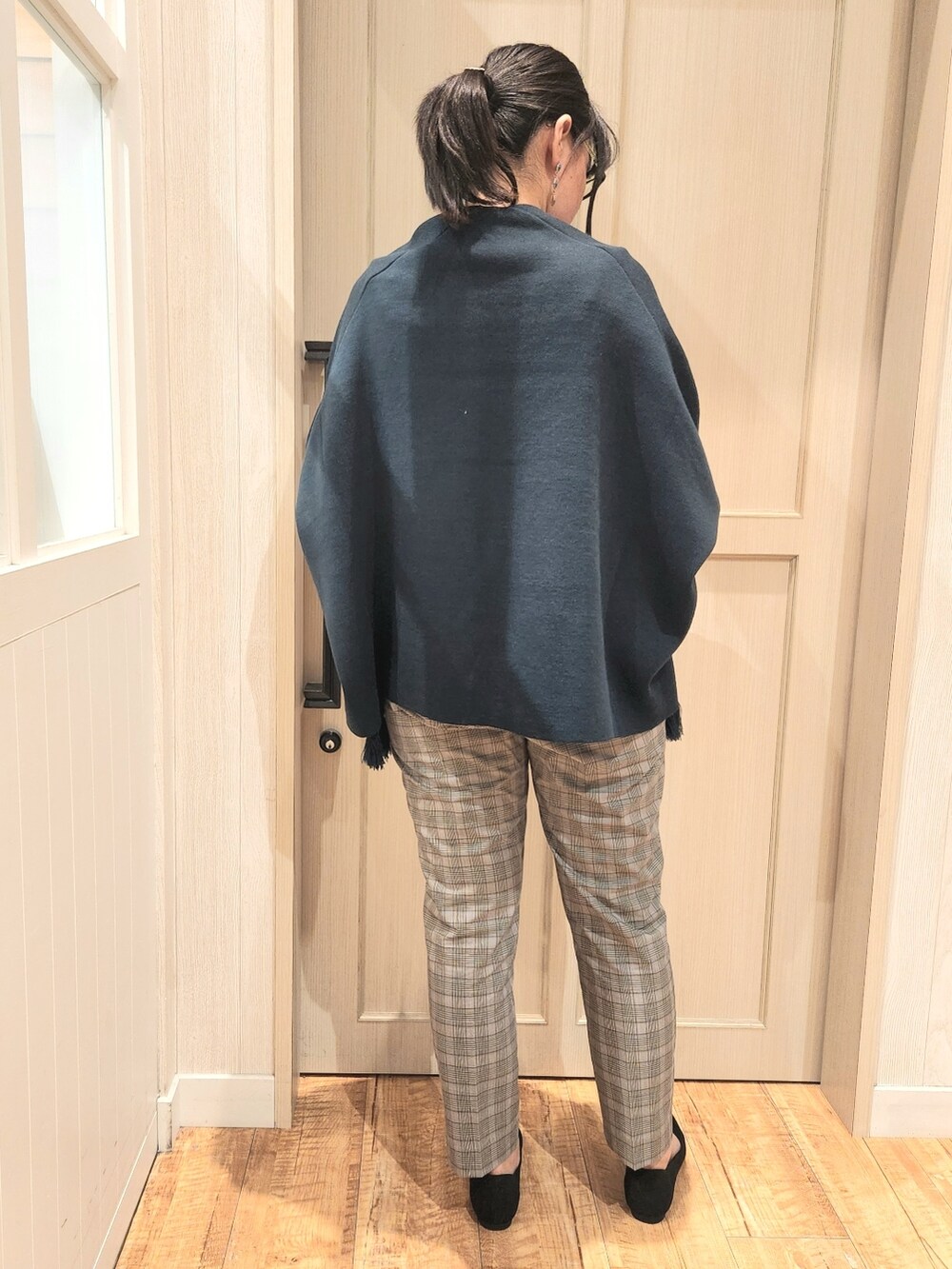 グリーン系のポンチョ、ブルー系のシャツ/ブラウス、グレー系のその他パンツを着用したレディースの秋コーディネートの3枚目の写真